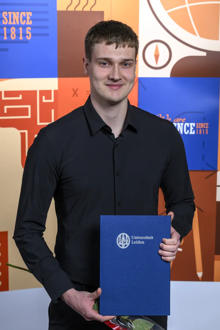 Dirk van den Beuken met zijn bachelordiploma van de Universiteit Leiden